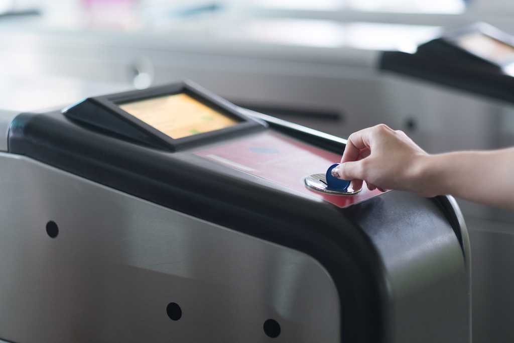 Hand insert subway chip into railway entrance