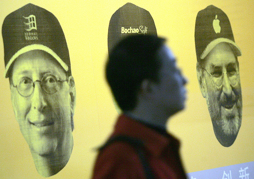 A Chinese jobseeker walks pass a poster