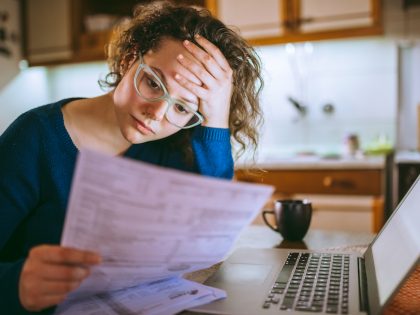 Woman going through bills, looking worried