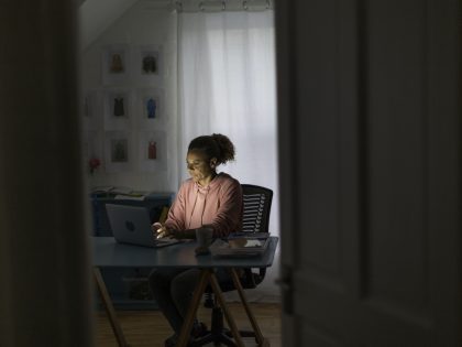 Mature woman working from home on a video call in the evening
