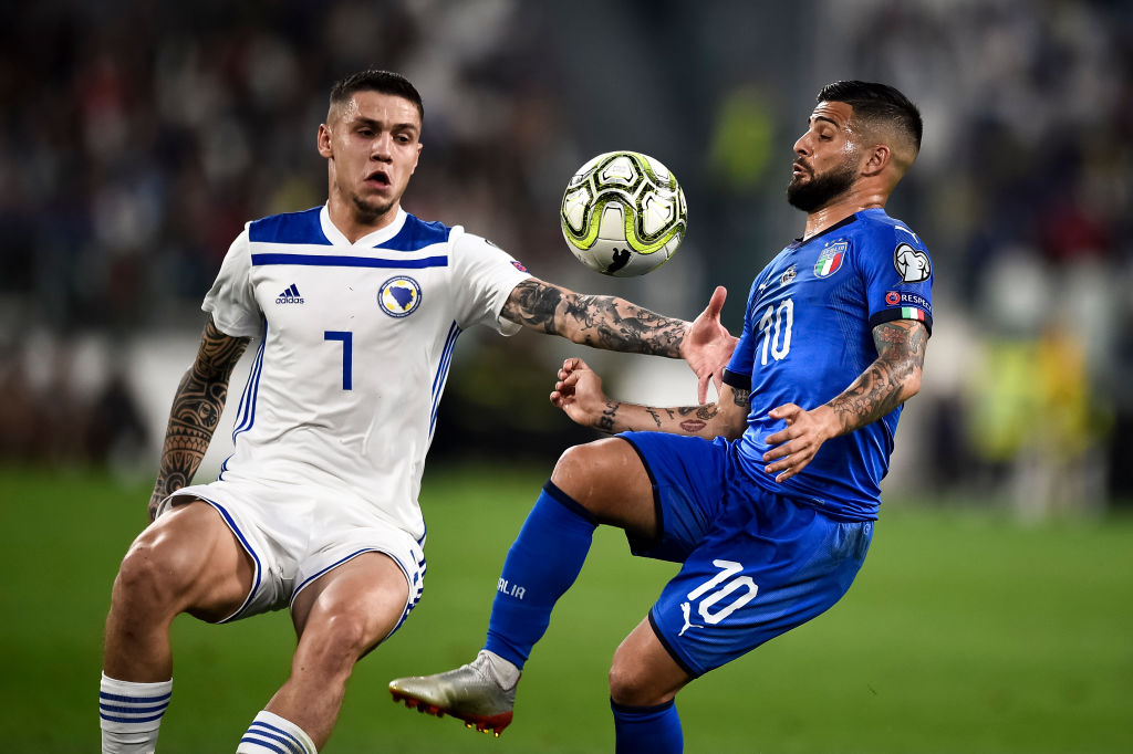 Lorenzo Insigne (R) of Italy competes for the ball with