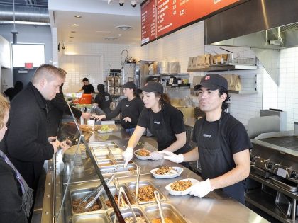 Danny Leon (on right) and Julia Calder (center) serve customers at Chipotle restaurant in South Por