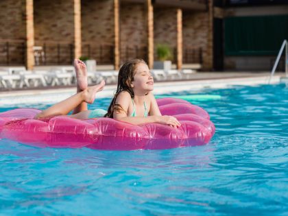 Teenage girl on air mattress at pool