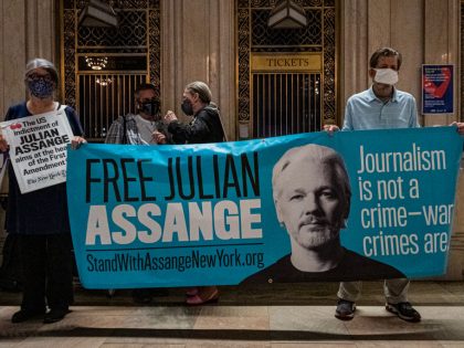 Protesters seen holding a banner at the protest. Free Julian