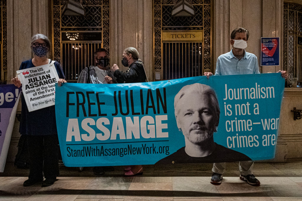 Protesters seen holding a banner at the protest. Free Julian