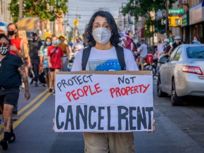 A participant holding a Cancel Rent sign at the protest.