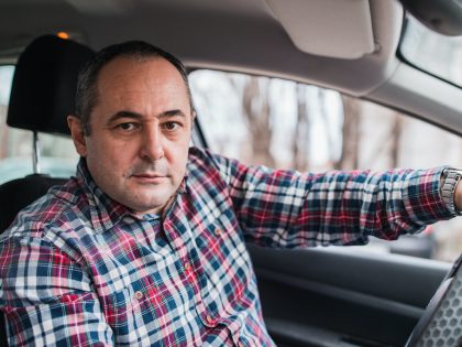Mid aged man sitting comfortably in his car
