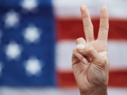 Human making Peace symbol on American flag background