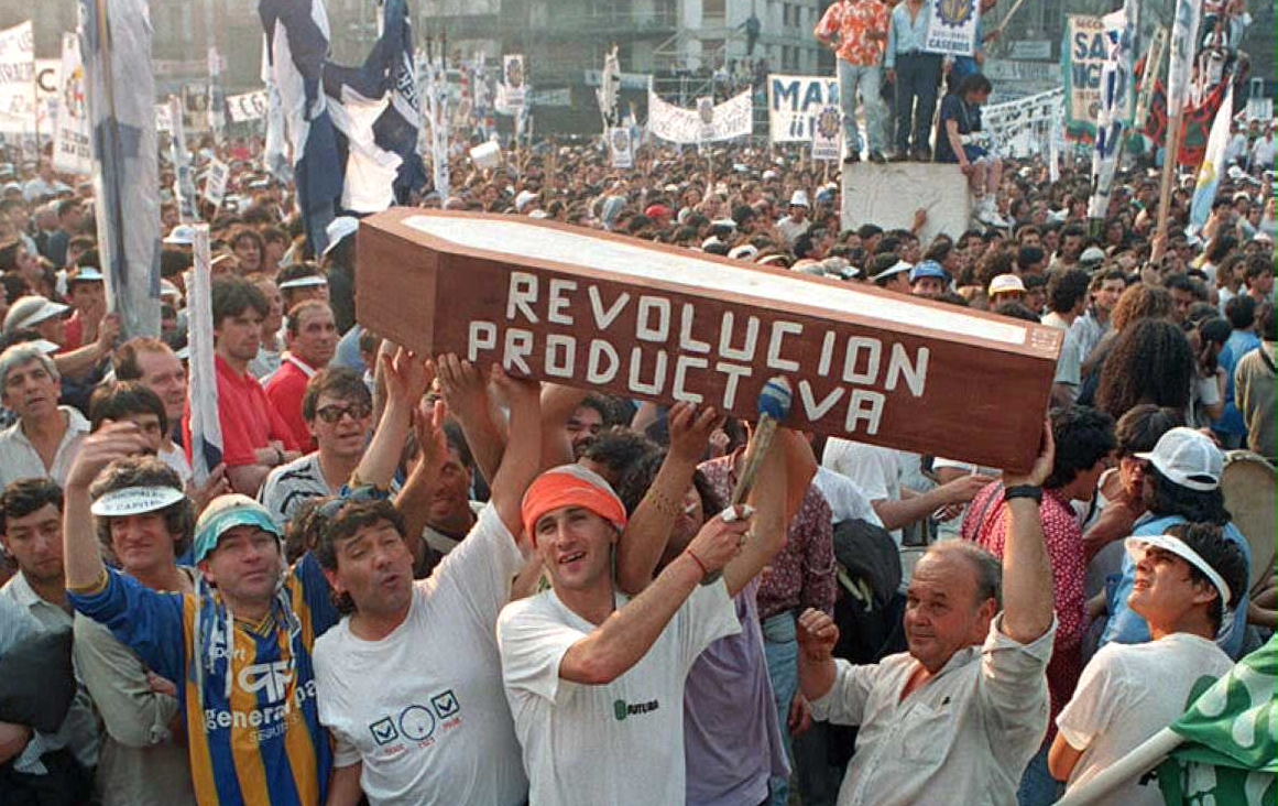 Trabajadores transportan un feretro con el slogan