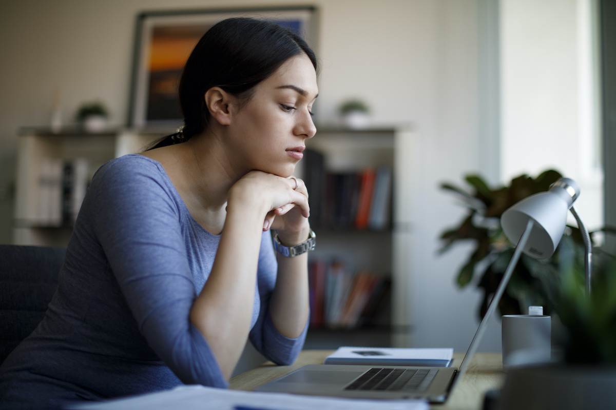 Bored young woman working at home