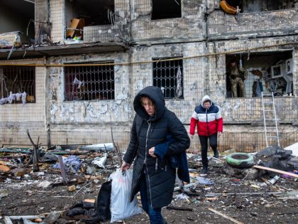 Residents leave the badly damaged residential building that