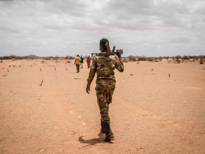 A soldier walks through a camp for displaced people on the