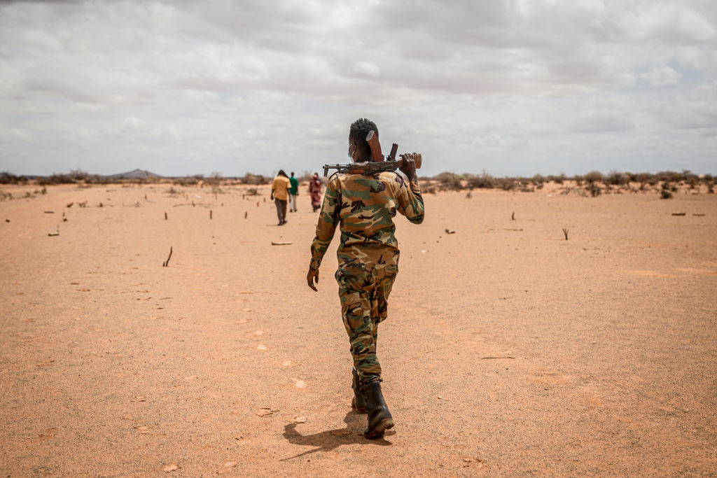 A soldier walks through a camp for displaced people on the