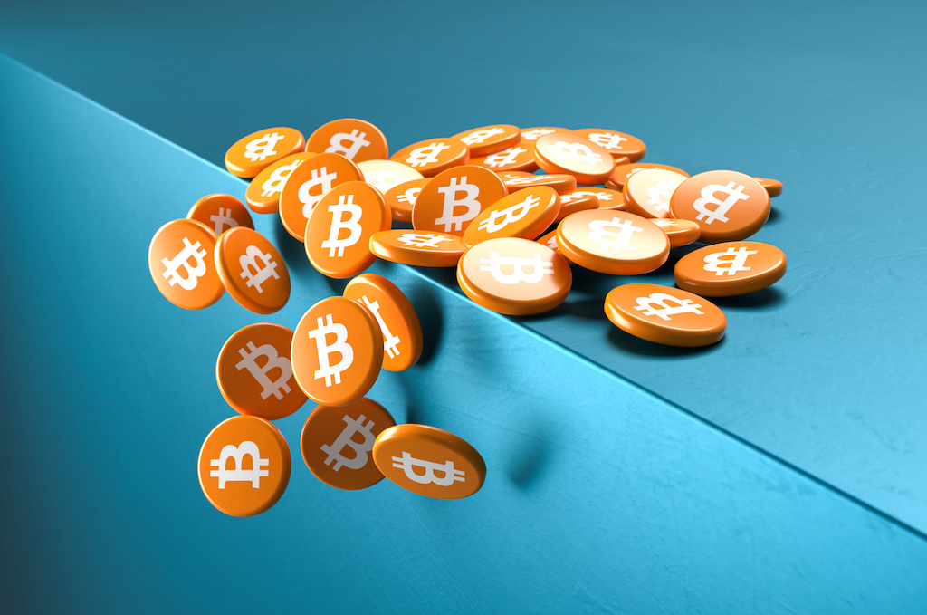 Crash of Bitcoin concept: Coin like cylinders with the bitcoin logo falling over the edge of a cube.