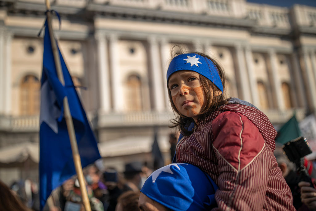 An indigenous child observes a Mapuche ritual during the