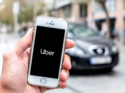In this photo illustration a Uber logo seen displayed on a