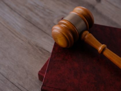 Judge gavel with books on wooden table