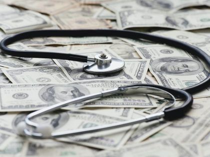 Stethscope on pile of US banknotes