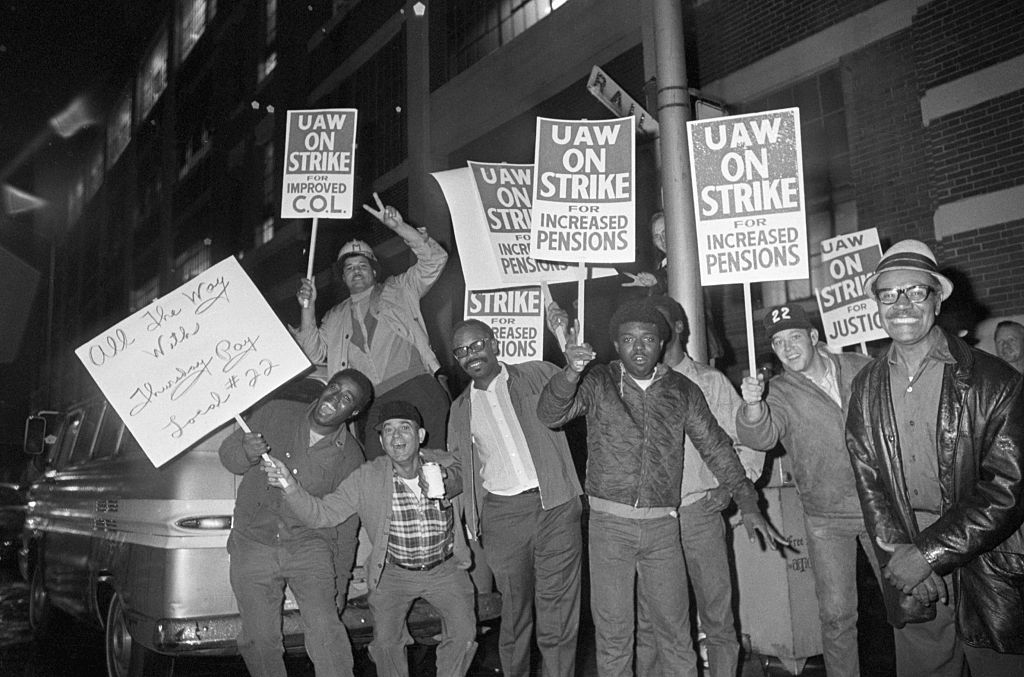 Workers on Strike Wave Picket Signs