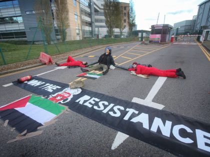 Three activists, joined together with a series of metal lock