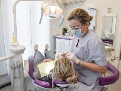 Female dentist examines a patient in a dental clinic