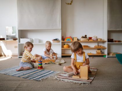Children focus on playing with eco-friendly natural toys on the floor in a bright room,