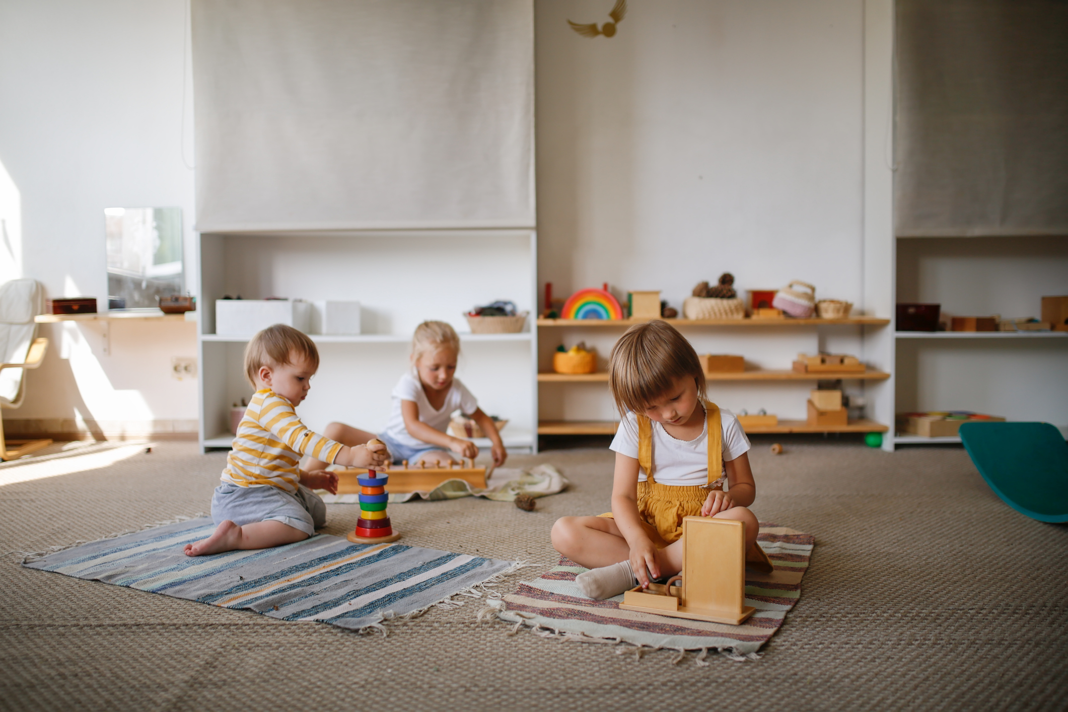 Children focus on playing with eco-friendly natural toys on the floor in a bright room,