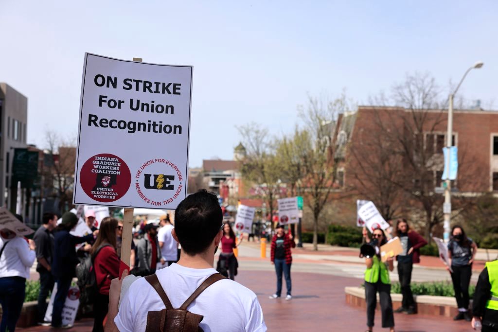 The Indiana Graduate Workers Coalition members hold placards