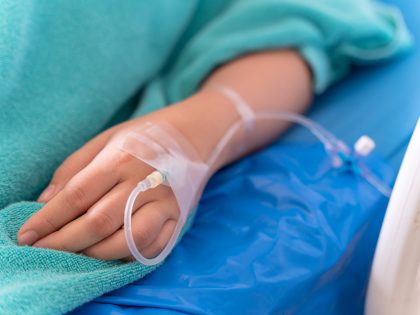 hand of the patient is on drip receiving a saline solution on bed VIP room at hospital. Medical Concept.