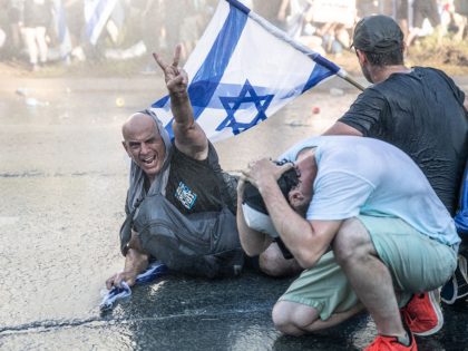 A protester is directly hit by police skunk water cannon
