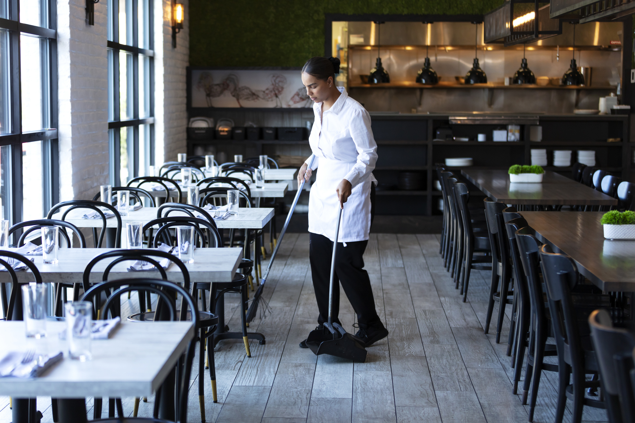 Restaurant worker sweeping the floor