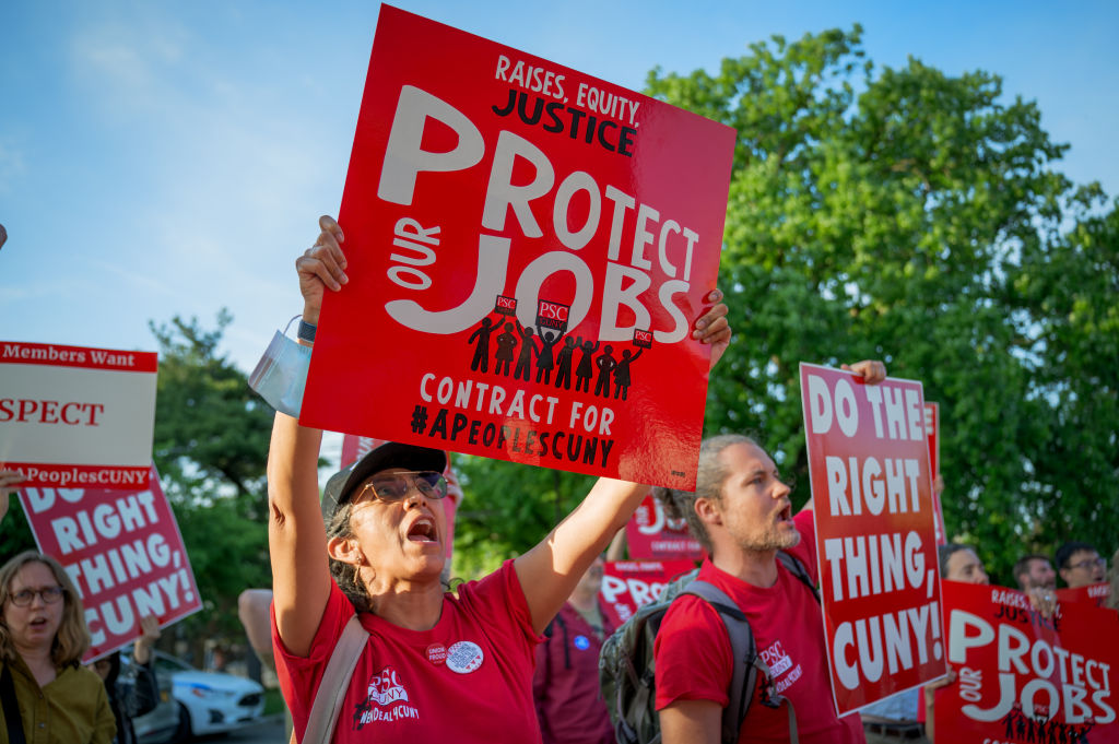 Participants holding signs seen protesting outside the