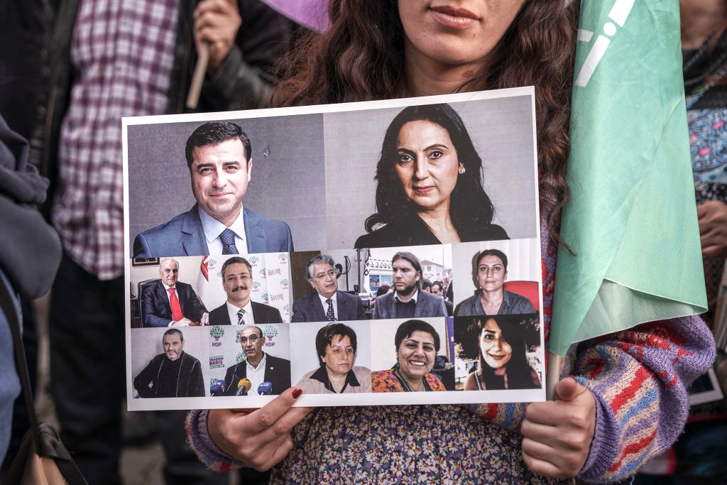 A protester holds a placard with portraits of former HDP Co-