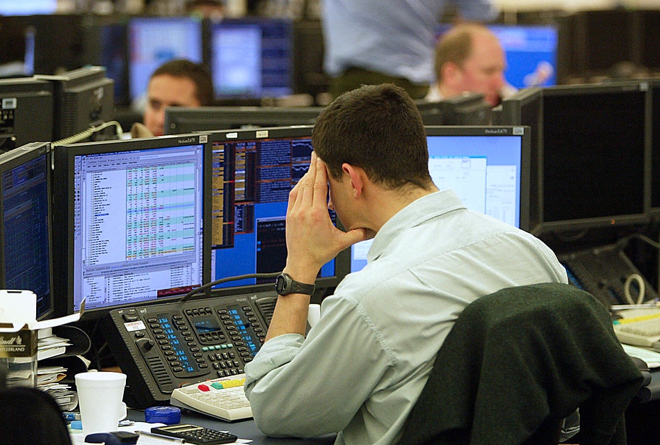 Analysts work on the trading floor at Go