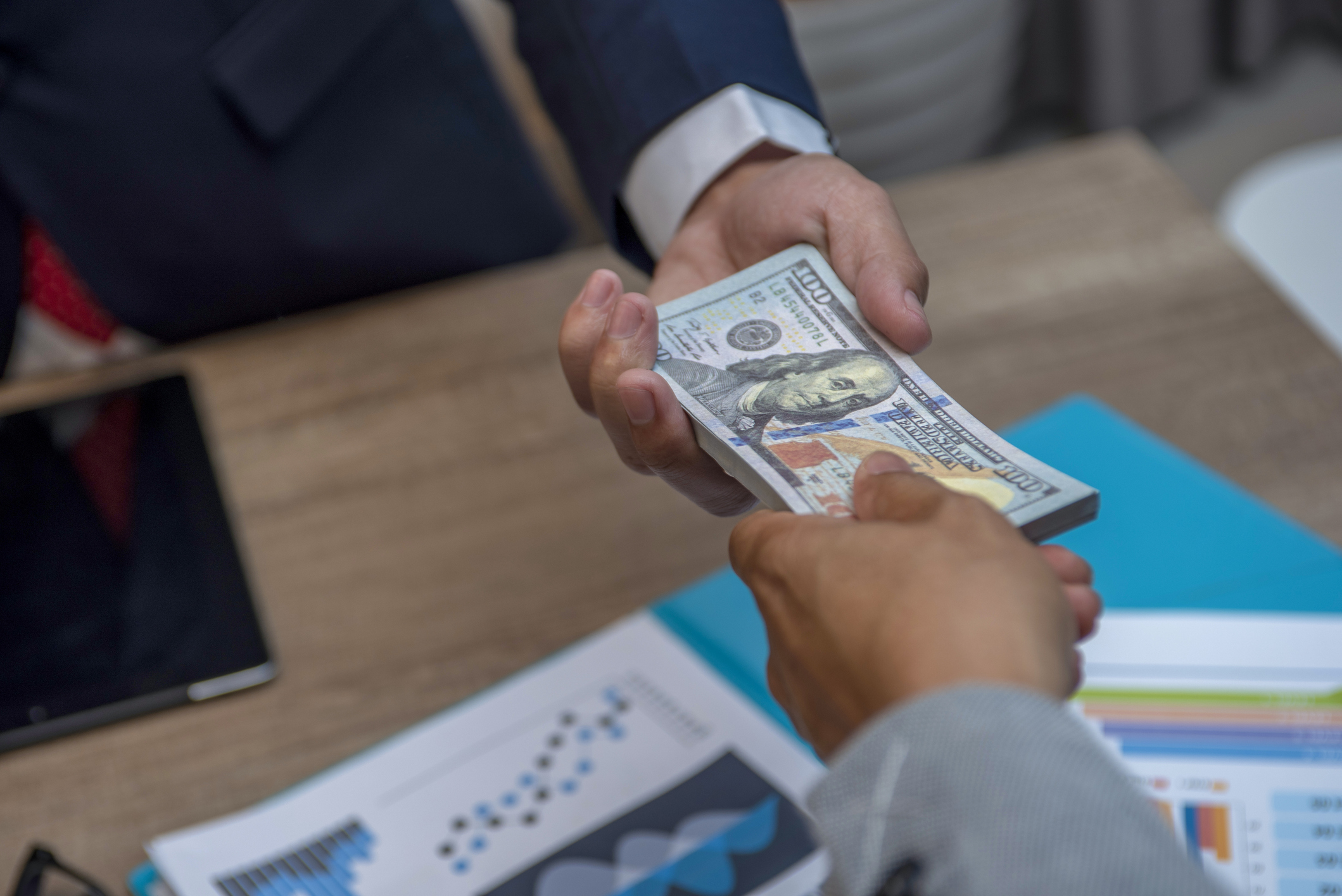 Businessmen secretly passing money - bribery and corruption concepts