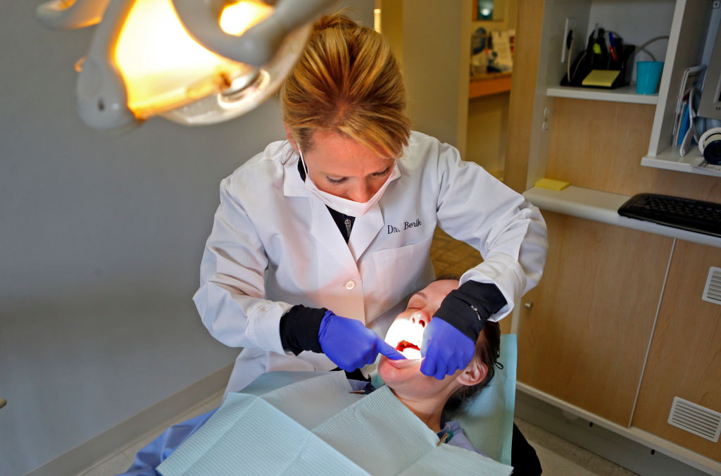 (Newton,  MA,  04/30/14)Dentist, Dr Anna Berik, performs an exam for oral cancer on Kacey Peone in her Newton office on   Wednesday,  April 30,  2014.  Staff Photo by Nancy Lane&amp;#010;