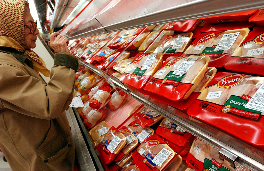 A shopper examines packages of Tyson brand chicken products