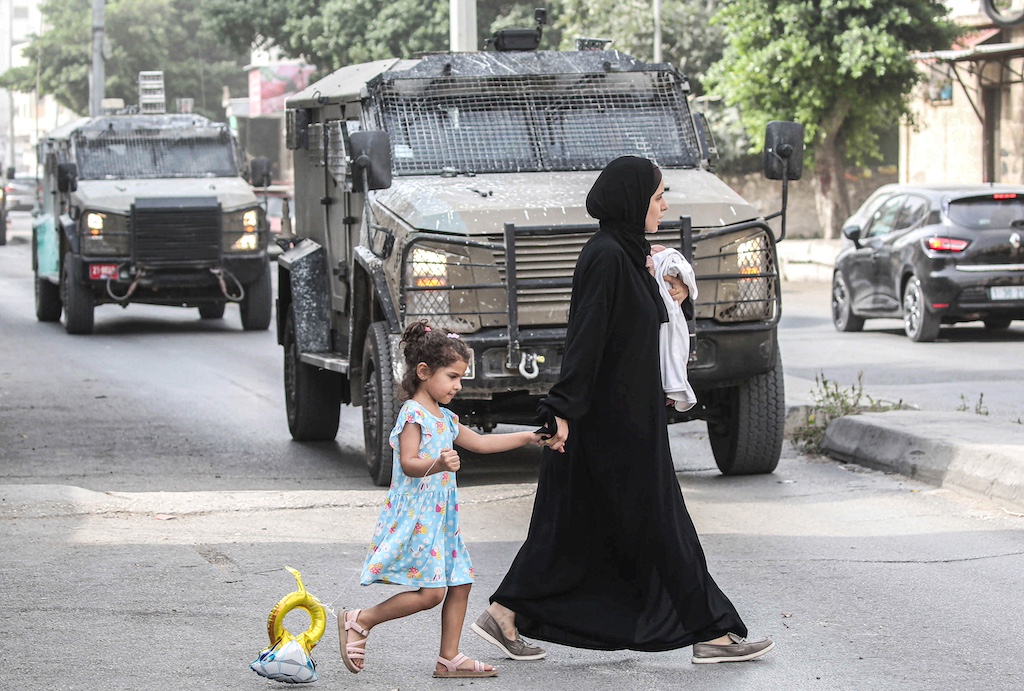 A mother and her daughter seen passing in front of an
