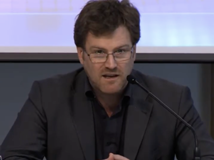 Peter D. Thomas delivers remarks at an academic event.