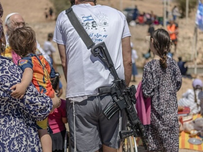 An armed Israeli settler is seen as Israelis celebrate their independence day in the occupied West Bank village of Ras Ein al-Auja,  on April 22, 2026. 