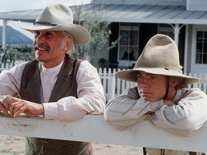 Robert Duvall (as Augustus "Gus'" McCrae) and Rick Schroder (as Newt Dobbs) lean on a fence in a scene from the television miniseries "Lonesome Dove," 1989.