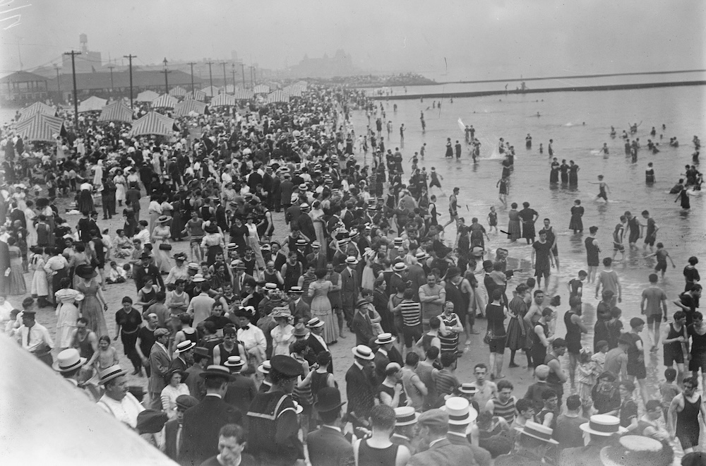 An archival photo of a crowded beach at Coney Island, from 1900
