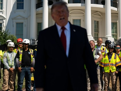 Construction workers watch as Donald Trump speaks to members of the media near the White House helipad construction on the South lawn of the White House in Washington, DC, on August 19, 2026. 