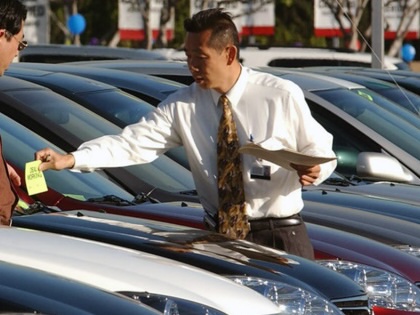 A car salesmen assists a customer at a Los Angeles Toyota dealership.