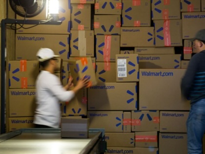 Employees load packages onto a truck inside a Walmart distribution center in Bethlehem, Pennsylvania, on March 29, 2017.