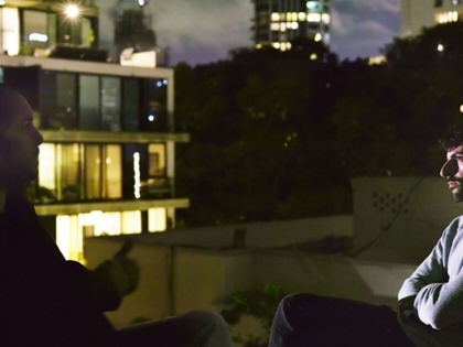 still of two men talking from film
