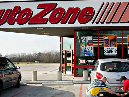 An Autozone employee helps a customer change a license plate bulb outside a store in Princeton, Illinois.