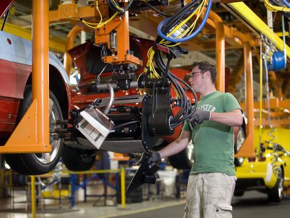Derek Hurlburt uses a power wrench to attach the tires to a
