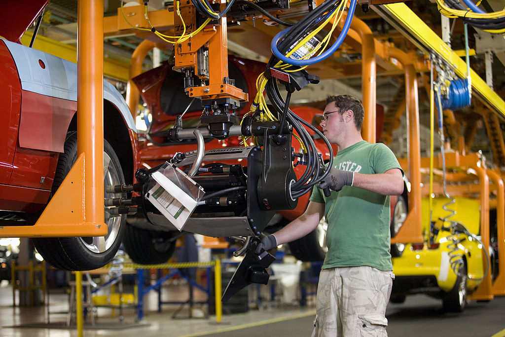 Derek Hurlburt uses a power wrench to attach the tires to a