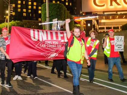 Striking workers march past Crown Casino shortly before